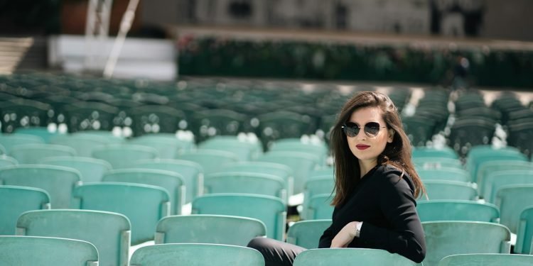 a woman sitting on a chair in a stadium