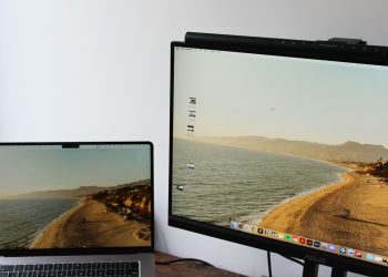 a laptop computer sitting on top of a desk next to a monitor