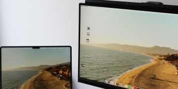 a laptop computer sitting on top of a desk next to a monitor