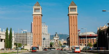 A city street with two tall towers in the middle of it