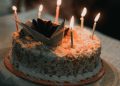a birthday cake with lit candles on a table