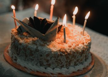a birthday cake with lit candles on a table
