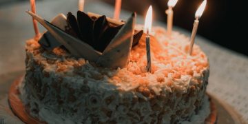 a birthday cake with lit candles on a table