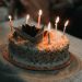 a birthday cake with lit candles on a table