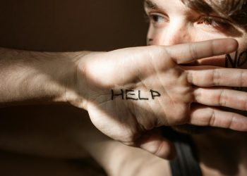 An expressive close-up of a hand with 'Help' written on the palm, symbolizing a need for assistance.