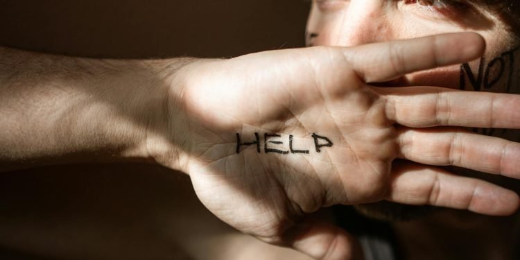 An expressive close-up of a hand with 'Help' written on the palm, symbolizing a need for assistance.